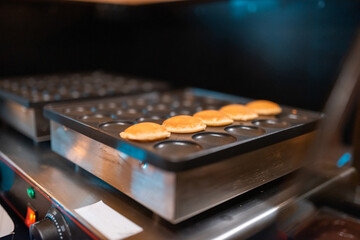 The process of making fresh delicious poffertjes. Making fresh poffertjes.Traditional Dutch batter treat. Selective focus
