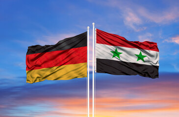 Germany and Syria two flags on flagpoles and blue cloudy sky