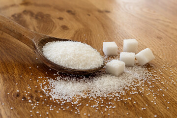Fototapeta na wymiar Sugar in wooden spoon, on wooden table