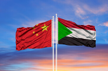 Sudan and China flag waving in the wind against white cloudy blue sky together. Diplomacy concept, international relations
