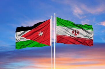 Jordan and Iran two flags on flagpoles and blue cloudy sky