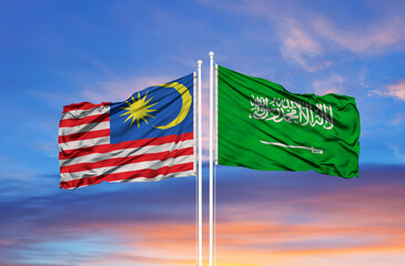 Saudi Arabia and Malaysia two flags on flagpoles and blue cloudy sky