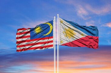 Malaysia and Philippines flag waving in the wind against white cloudy blue sky together. Diplomacy concept, international relations
