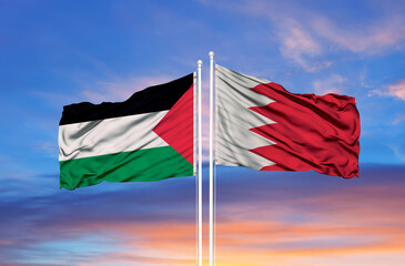 Palestine and Bahrain flag waving in the wind against white cloudy blue sky together. Diplomacy concept, international relations