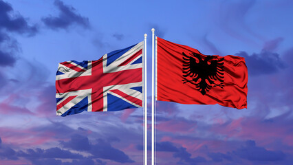 United Kingdom and Albania two flags on flagpoles and blue cloudy sky