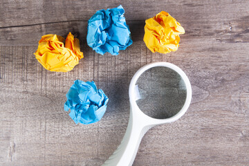 magnifying glass and crumpled papers on the table