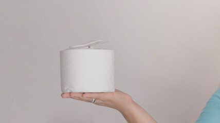 Woman's hand with toilet paper on the hand and a face mask for the prevention of viruses, on top of the toilet paper.