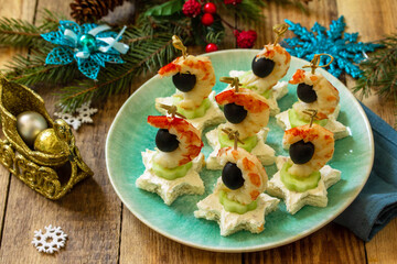 Festive snack of canapes on the Christmas table. Canapes with cheese, cucumber and shrimps.