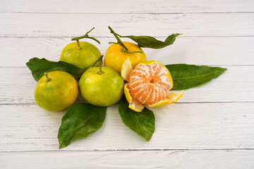 Fresh , green-yellow colors mandarin or tangerines. White woden background.