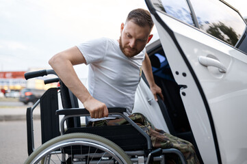 Retired veteran transfers from car to wheelchair