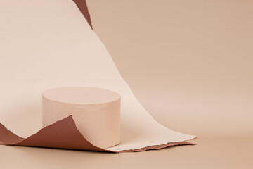 Abstract trendy composition with empty round podium platform for product presentation and curve shaped torn brown paper edges on pastel beige background. Front view