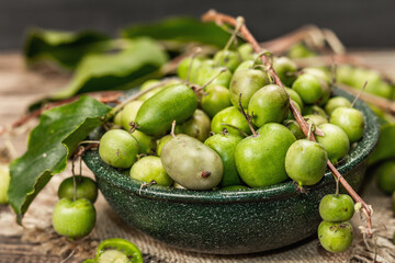 Harvest of ripe Actinidia arguta kiwi in a ceramic bowl