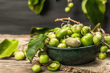 Harvest of ripe Actinidia arguta kiwi in a ceramic bowl