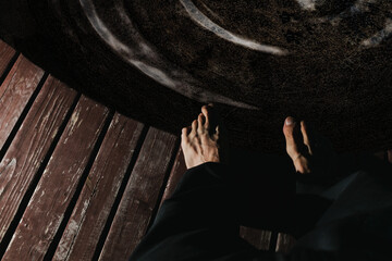 The legs of an adult man on a wooden platform