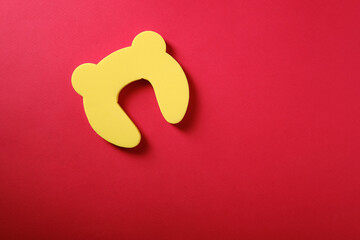 Child protection on the door on a red background, top view