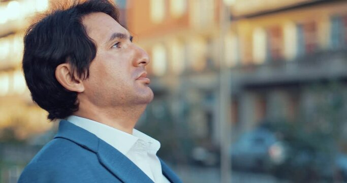 A man in a jacket takes off his mask and breathes in air with relief. The European takes off his mask and takes a deep breath. A person enjoys life without a medical mask.
