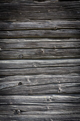Wooden logs of an old house. Close-up. Weathered natural gray wood texture. Background. vertical photo.