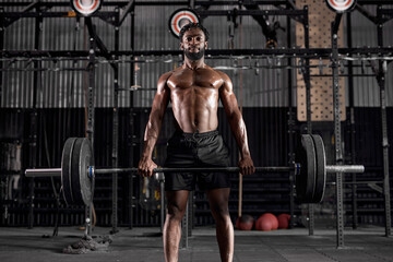Fototapeta na wymiar Fit strong bodybuilder athletic fitness man pumping up muscle, workout at gym. bodybuilding concept. athletic handsome bodybuilder african man doing fitness health care exercises in gym, naked torso