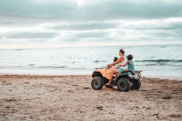Obraz premium Casablanca, Morocco 04-10-2021: a father with two children driving a quad in a beach in Morocco