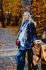 A young beautiful smiling pregnant woman in a warm knitted outfit on a cozy autumn walk, a lifestyle in the fresh air.