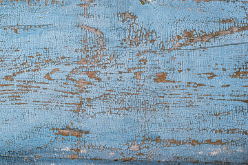 Part of a wooden surface with cracked blue paint
