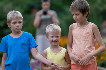 Mom takes pictures of children in park against background of flowers