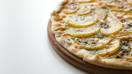 Pizza with cheese and pear fruit on cutting board