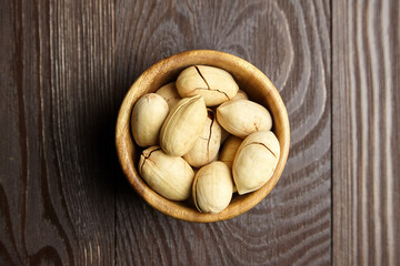 Pecan nuts in bowl on wooden table top view