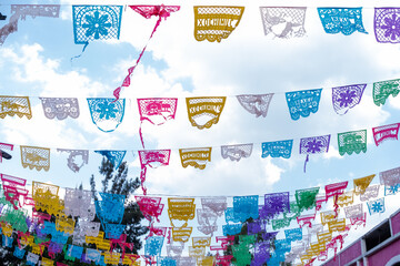 Fototapeta na wymiar Colorful Mexican paper banners under slightly cloudy sky