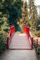 Red wooden bridge in a park. Beautiful nature