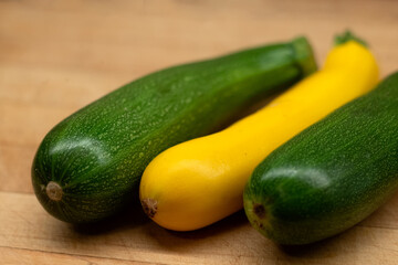 Green and yellow zucchinis on a wooden surface