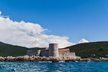 Fototapeta na wymiar An island with the former Austrian fortress Arza. Mamula Island. Bay of Kotor, Adriatic Sea. Close-up view from the sea from the yacht.