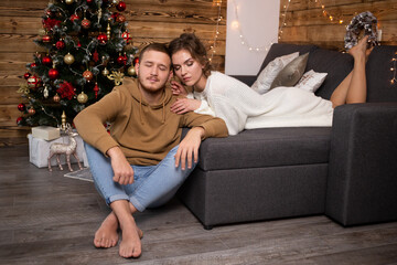 Obraz premium Couple in love near nicely decorated Christmas tree, enjoying the Christmas