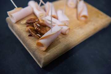 Fresh turkey ham rolls and nuts on a cutting board