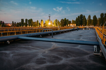 Modern wastewater treatment plant. Tanks for aeration and biological purification of sewage at night - obrazy, fototapety, plakaty
