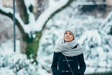 Beautiful young woman wearing scarf and a a hat on a cold winter day