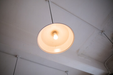 Low-angle view of a lamp hanging from white ceiling