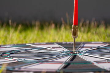 Close up shot red dart arrow hitting in the target center of dartboard,Business goal or target...