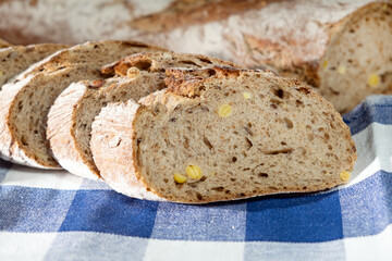 Freshly prepared grain bread slices on a kitchen towel. Various nuts in self made home bread. Closeup