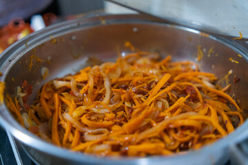 Delicious yam, carrots, tomato, and onion slices in cooking pot