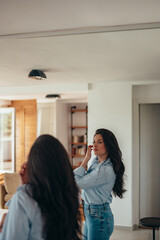 Attractive young businesswoman getting dressed for work at home