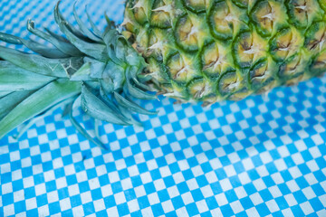 Fresh pineapple on blue and white checkered tablecloth