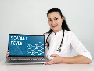  SCARLET FEVER inscription on the screen. Close up Oncologist hands holding black laptop.