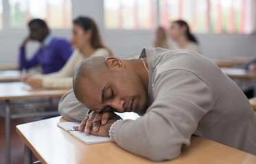 Tired student fell asleep in lesson in a university classroom