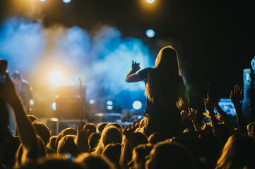Girl in a audience crowd having fun and enjoying concert on a festival