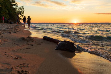 People watching sunset on Lake Michigan Beach.  - obrazy, fototapety, plakaty