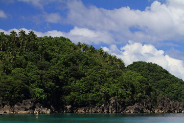 Fototapeta na wymiar girl paddling an SUP stand up paddle board by herself in a calm tropical ocean. Philippines