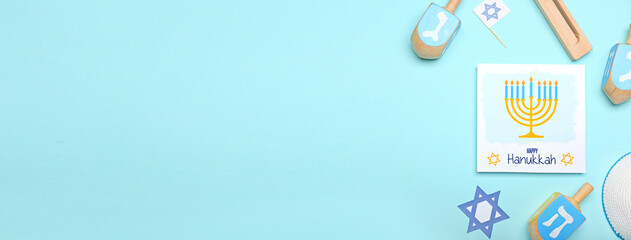 Different symbols of Hanukkah and greeting card on color background with space for text