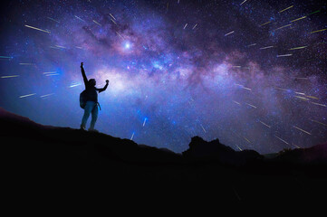 Landscape with Milky Way. Night sky with stars and silhouette of a standing happy man on the mountain, Success or winner, leader concept. High iso with Noise.