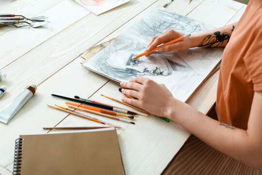 Young female artist drawing in workshop